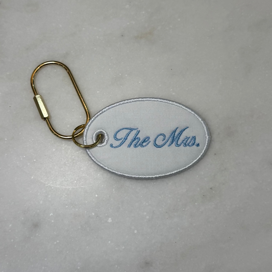 Keychain with 'The Mrs.' text on a marble surface