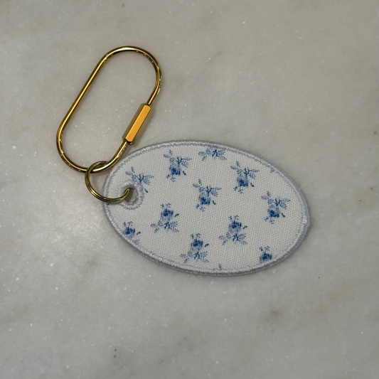 Keychain with blue floral pattern on a marble surface
